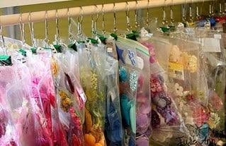A rack full of reusable bags of different kinds of flowers.