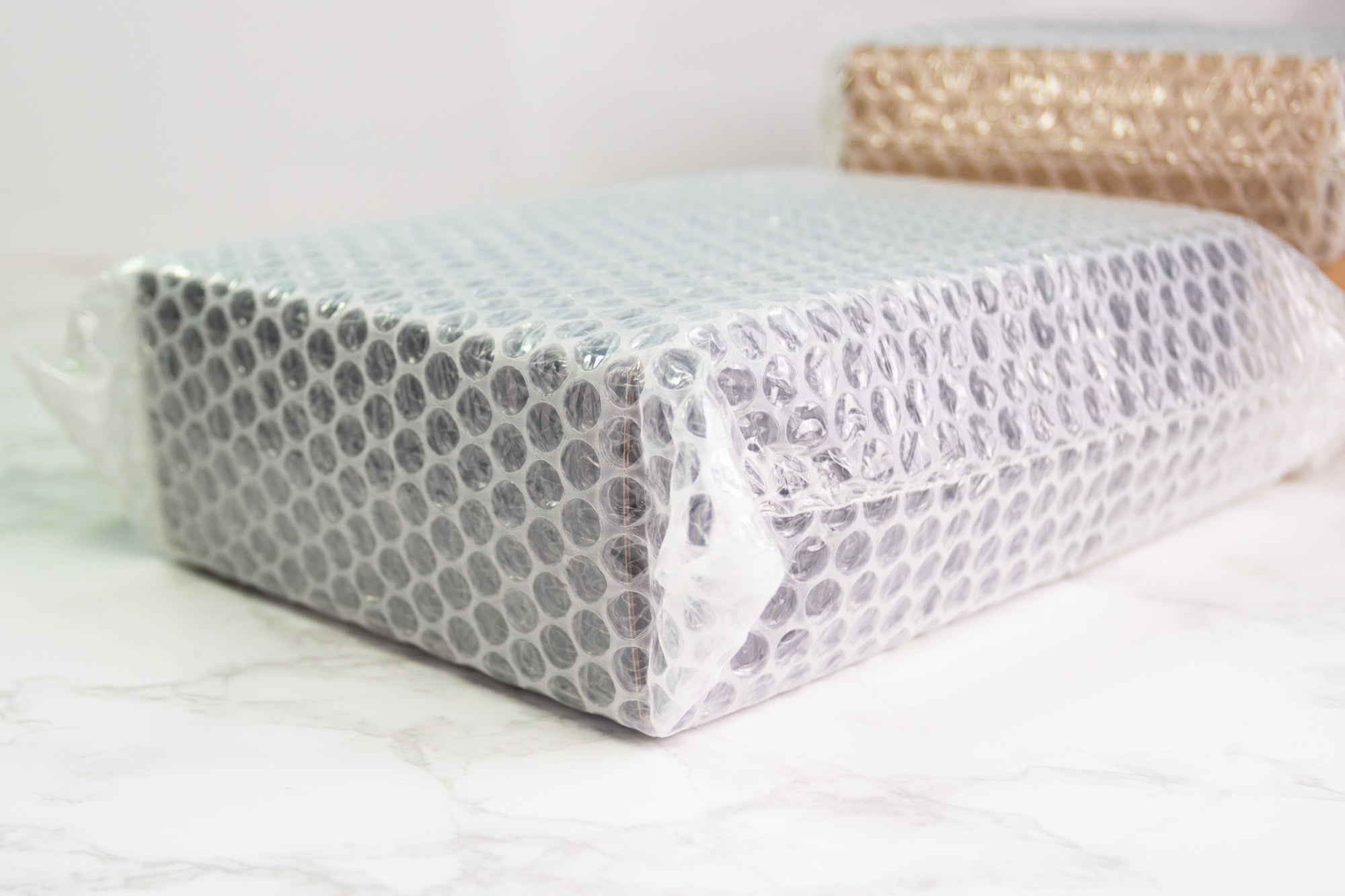 A silver box with a plastic cover sitting on a marble table.