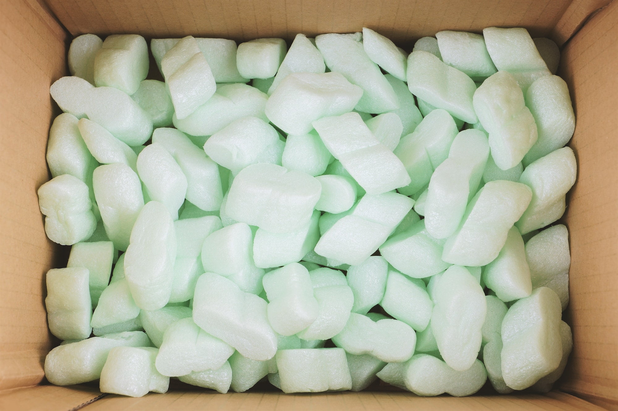 A box filled with green foam cubes.