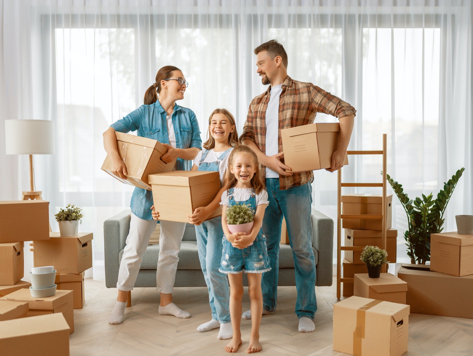 A family with moving boxes in a living room.