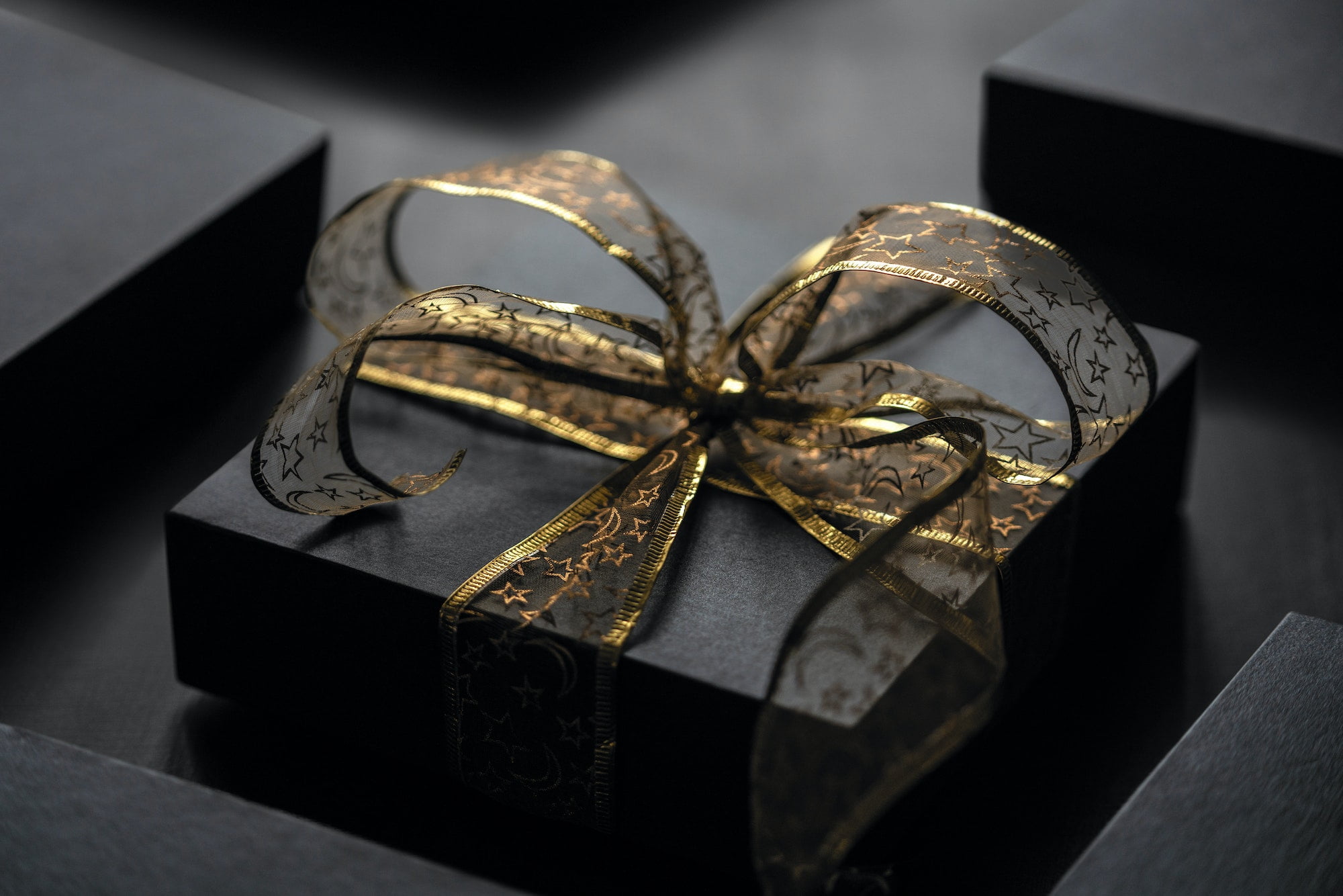 A black gift box with gold ribbon.