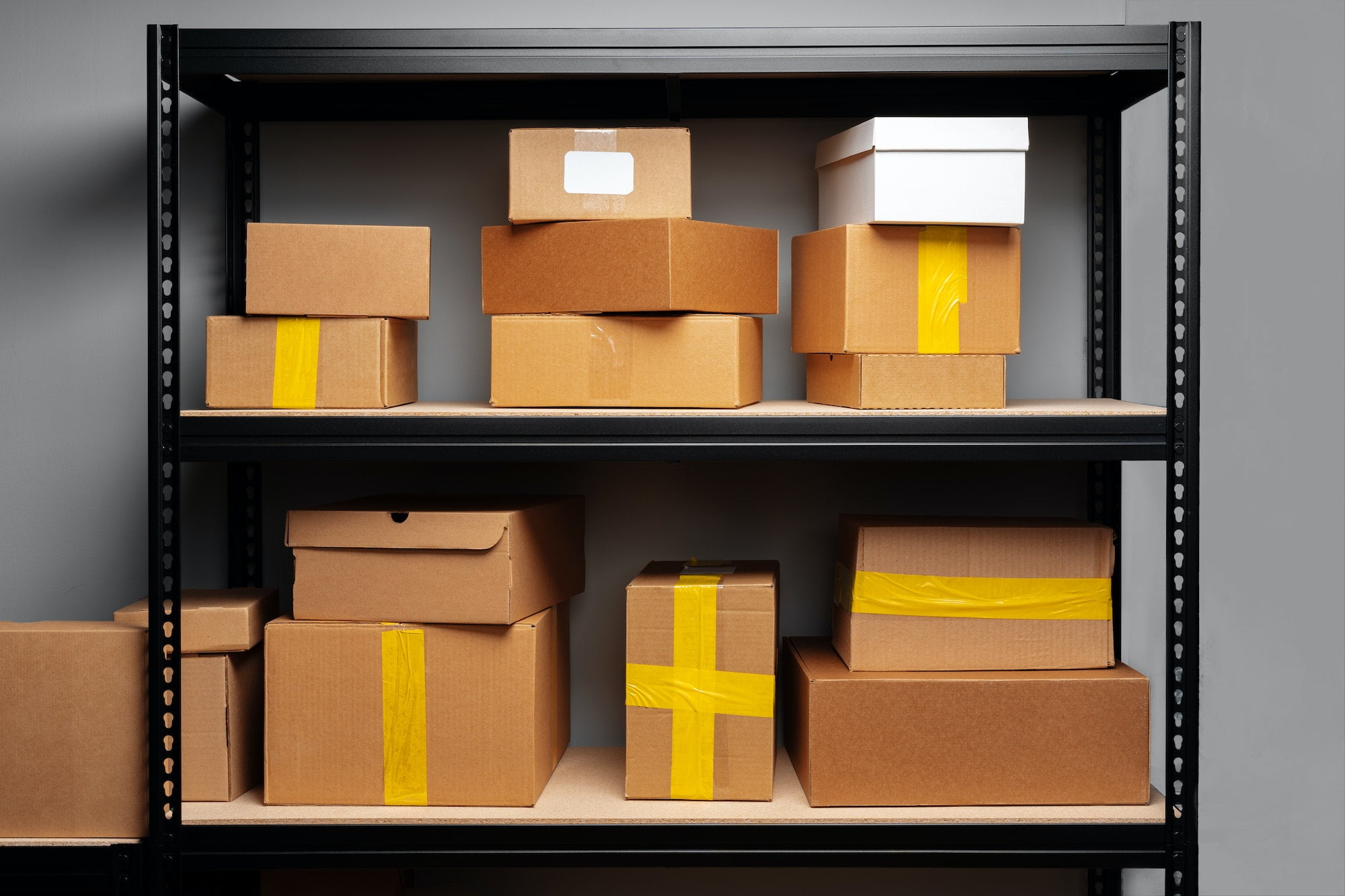 Various boxes on a shelf with yellow tape.