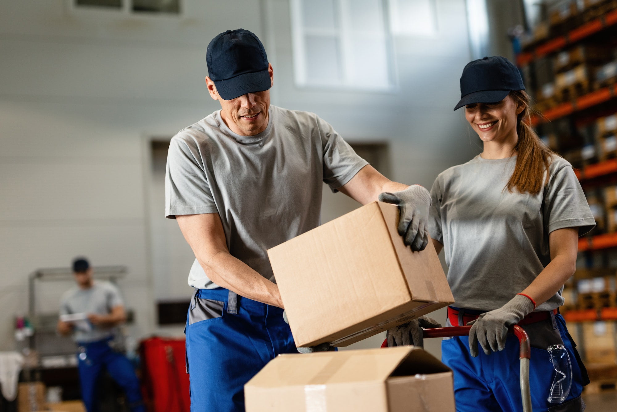 A man and a woman working in a warehouse.
