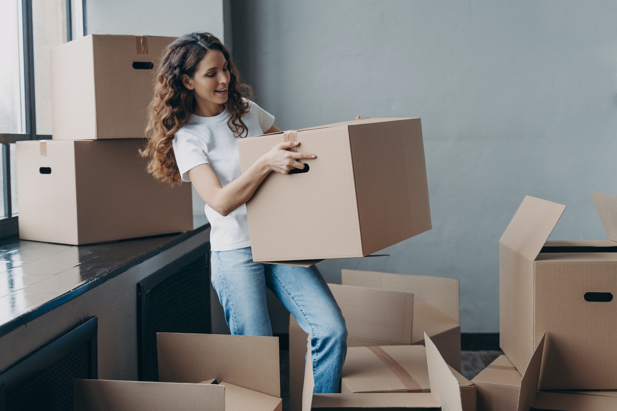 A woman is moving into a new apartment with boxes.
